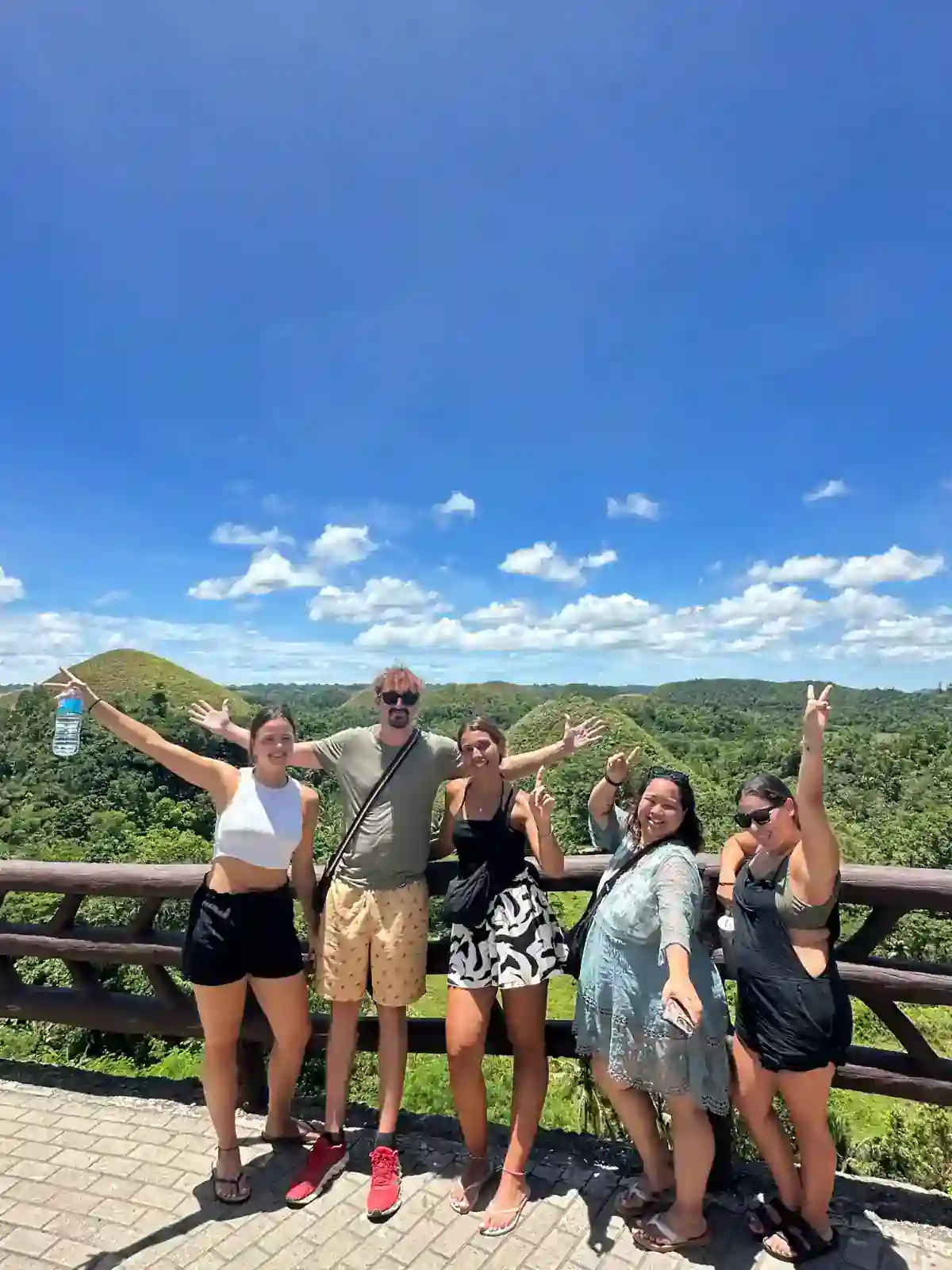Travellers at the Chocolate Hills viewpoint in Bohol, Philippines, under clear skies