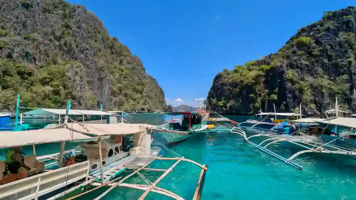 Outrigger bangka boats moored between limestone cliffs in a Coron lagoon, Palawan