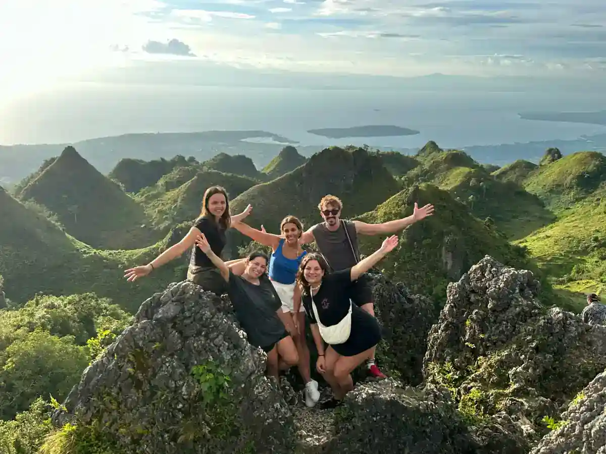 Group at Osmeña Peak, Cebu, with clear sunlit views over the jagged hills and coastline in April