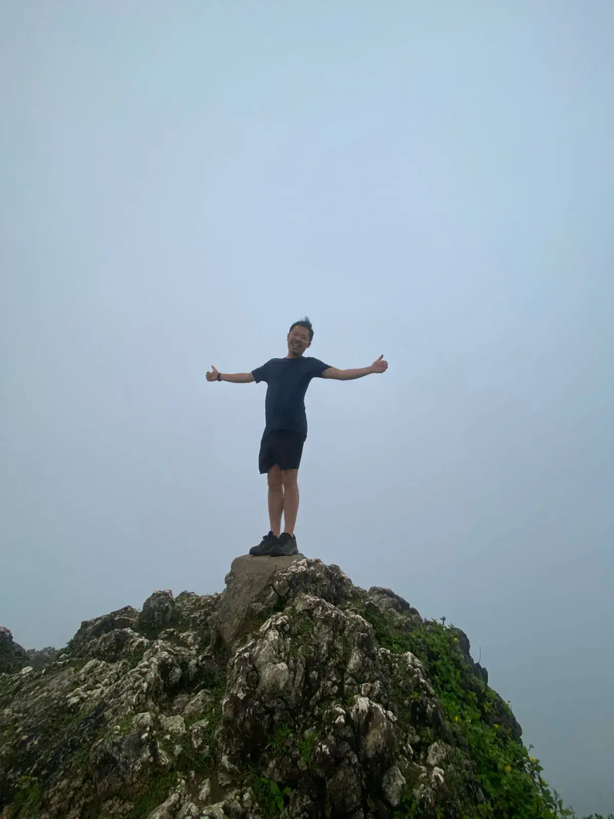Traveller on the summit rocks at Osmeña Peak, Cebu, with the viewpoint fogged in during December